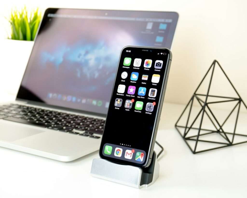 ノートPCとスマートフォンが置かれたデスク